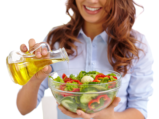 Women obtains omegas from olive oil on salad